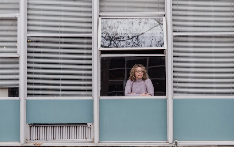 NEA Today cover image: Woman looking outside a school building